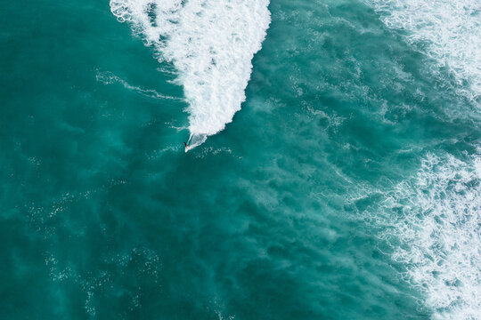 Drone shot of solo male surfer on wave in Honolulu, Hawaii