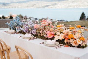 Vibrant florals and colorful place setting on wedding table