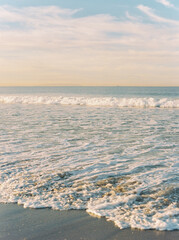 The waves of the Pacific Ocean on Venice Beach at sunrise.