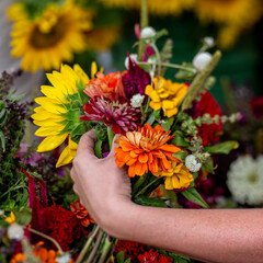 A woman's hand holding a bouquet of flowers.