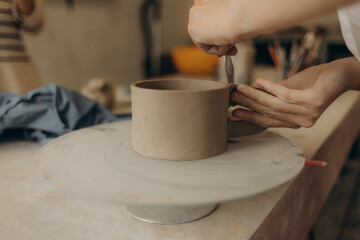 Female master paints a pot, pottery workshop