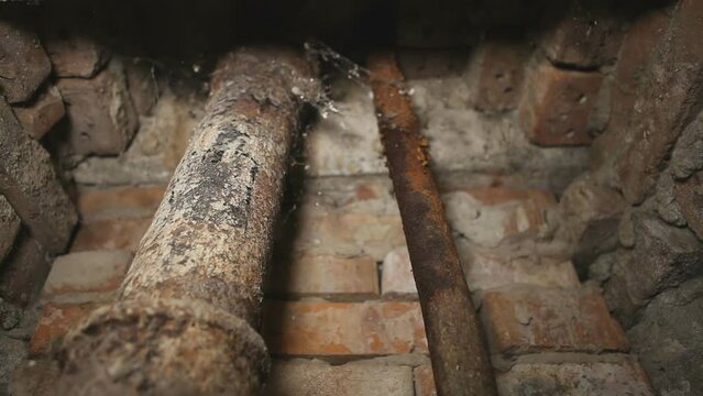 Old rusty cast iron sewer pipes in the basement. Looping, endless.