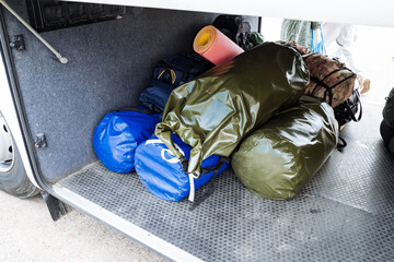 The cargo compartment is meticulously organized with camping equipment and sleeping bags, all set...