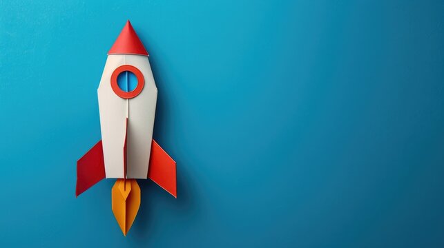 Rocket paper craft taking off with copy space on a blue background symbolizing back to school