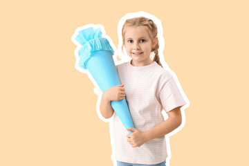 Cute little girl with blue school cone on beige background