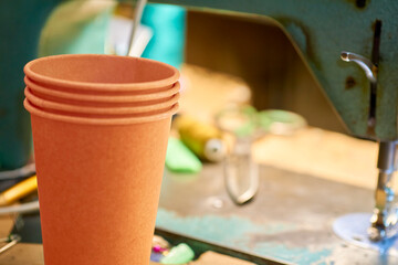 Coffee break,tea time.Orange paper glasses in tailor workshop