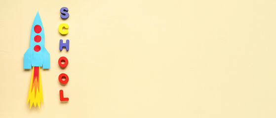 Paper rocket with word SCHOOL on beige background