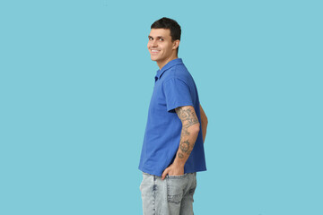Fototapeta premium Handsome young man in stylish t-shirt on blue background