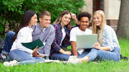 Team of students studying in group project outdoors in university campus, copy space