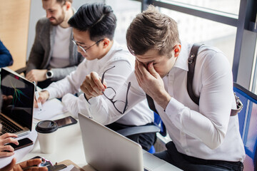 Group of strategy managers reading last business reports from exchanges on laptop and pesonal...