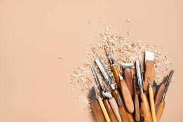 Carpentry workshop desk with set of different handmade carving tools for working with wood top view.