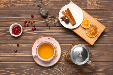 Cup of hot tea with cranberry on wooden table