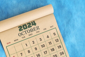 October 2024 calendar flat lay in blue background with copy space.