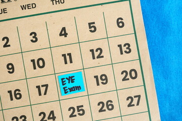 Eye exam or checkup schedule concept. Written reminder note on calendar.