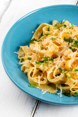 Piatto di deliziose fettuccine Alfredo, ricetta tipica di pasta all'uovo condita con burro e parmigiano, cibo italiano 