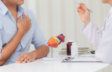 Fototapeta premium Cardiologists consult and treat patients by showing them an anatomical model of the human heart. medical concept