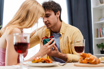 Romantic couple enjoying a festive dinner exchanging gifts and sharing love