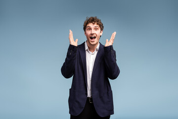 Excited businessman raising hands in excitement celebrating success