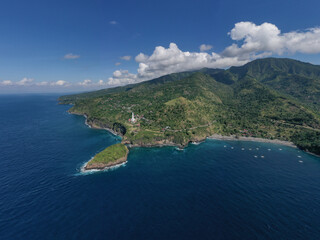 Majestic drone view of the coastline east Bali, where green hills merge with the deep blue sea.