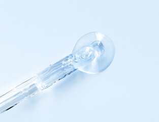 pipette with serum drop on a blue background