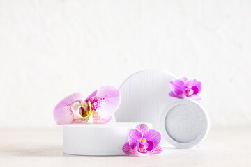 Decorative podiums with beautiful orchid flowers on white background