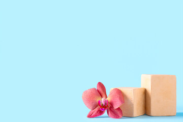 Decorative podiums with beautiful orchid flower on blue background