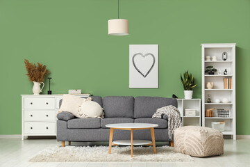 Modern interior of living room with cozy sofa, coffee table and shelving unit