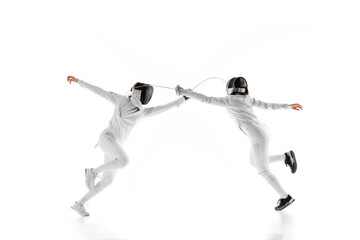 In preparation for match, two female fencers go head-to-head, each trying to outmaneuver other against white studio background. Movement. Concept of professional sport, competition, action. Ad