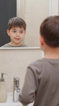 boy and baby child in bathroom,brushing teeth,washing hands with soap,combing hair.siblings,brothers in front of sink on tabouret chair.kids on toilet with lot of paper.