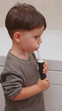 boy and baby child in bathroom,brushing teeth,washing hands with soap,combing hair.siblings,brothers in front of sink on tabouret chair.kids on toilet with lot of paper.