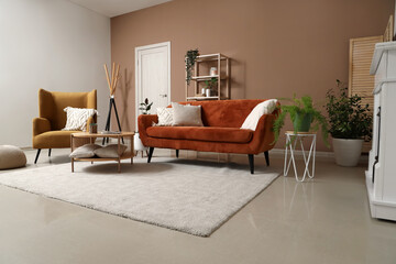 Interior of living room with sofa, armchair and soft carpet