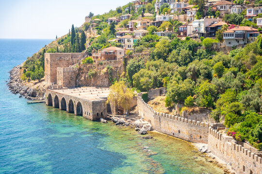 Ancient shipyard or Tersane near of Kizil Kule tower and beautiful beach and calm turquoise sea surface in Alanya, Turkey