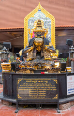 The statue of Rahu swallowing the moon, a black and gold color, which is worshipped by many Buddhists and often visited to pay homage, at Bang Yai Temple, Nonthaburi, Thailand.