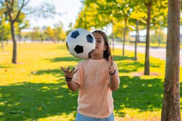 9 Year Old Girl Playing With A Ball Outdoors On A Sunny Day In The Park.