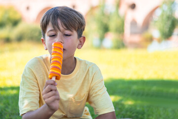 9 Year Old Boy Eating Ice Cream Outdoors On A Sunny Summer Day
