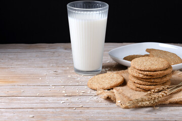 Healthy oatmeal cookies and milks on wooden table. Copy space	