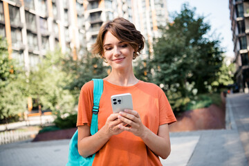 Photo of positive cute adorable girl dressed trendy clothes writing sms social media correspondence...