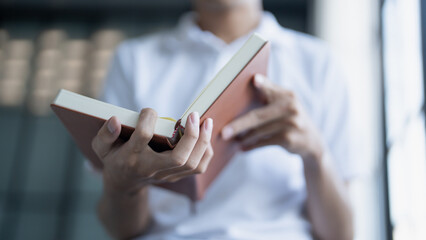 Man is engrossed in a book with a focused expression showcasing the joy and concentration of reading.