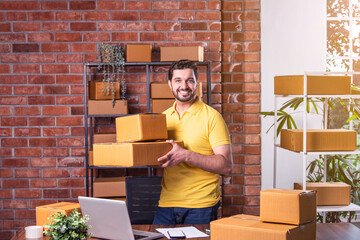 Indian asian Man Using Laptop and Smartphone to Manage and Ship Online Orders from Warehouse