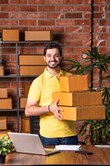 Indian asian Man Using Laptop and Smartphone to Manage and Ship Online Orders from Warehouse