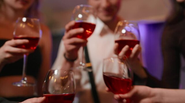 Celebrating Christmas or B-day, closeup of clinking glasses with champagne. Merry friends party, young people cheering and congratulating each other, drinking alcoholic drinks in bar or nightclub
