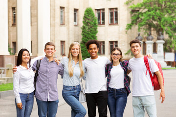 Obraz premium Student life. Classmates posing in front of university and smiling to camera