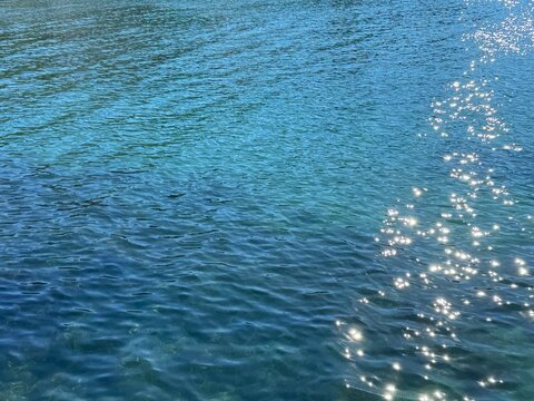 Blue calm sea with shiny sun glare on surface