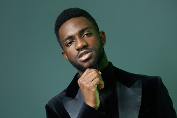 Confident african man in a black suit and turtleneck striking a pose against a stylish urban...