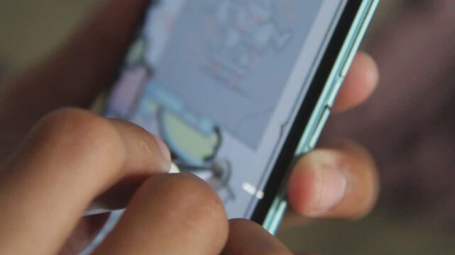 Male drawing on his mobile phone screen using it is electronic pen  doing sketches 
