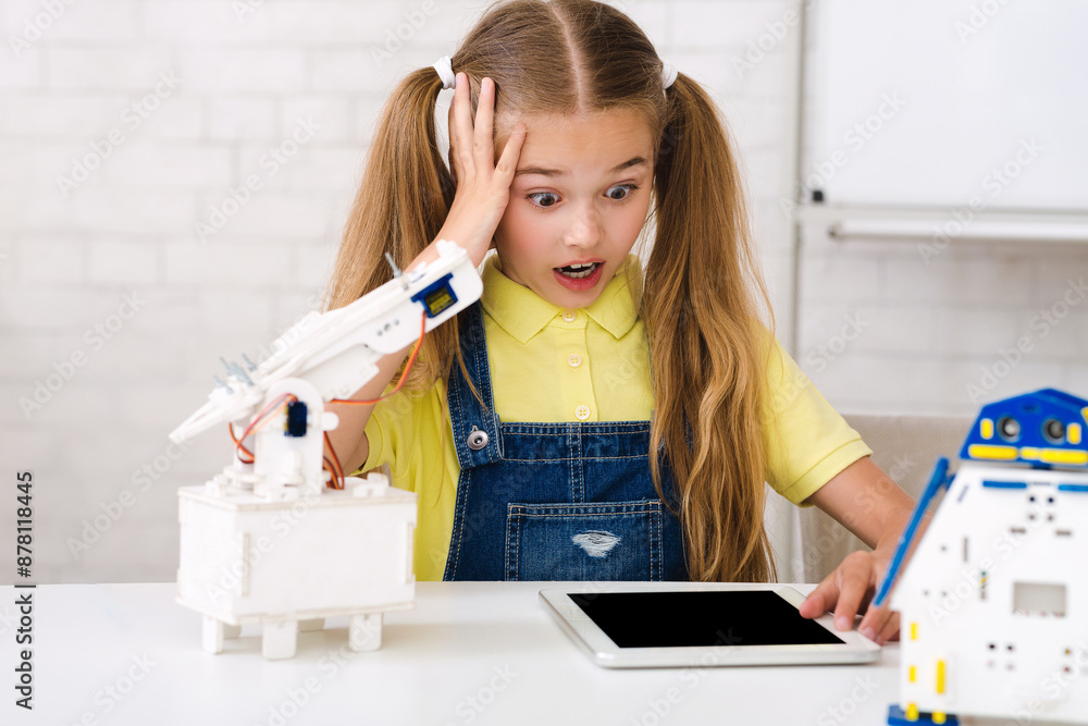Poster a young girl with pigtails looks surprised and concerned as she works on a robotics project. she is 