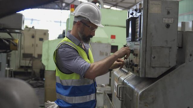 Factory worker. Man Working on a factory machine. Staff operate control heavy machine in factory.