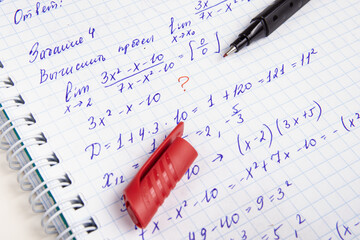 Learning mathematics. Calculating the mathematical limit. Checking homework with red pen. "Calculate the limit"