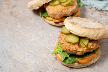 Two hamburgers with pickles on top