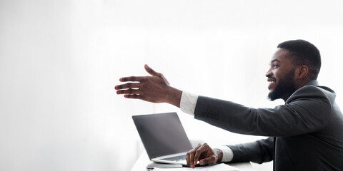 Friendly black HR manager extending hand for handshake after successful job interview, side view with copy space